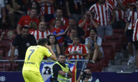 Penyerang Villarrea Gerard Moreno merayakan golnya di depan tribun pendukung Atletico Madrid.