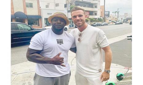 Penyerang Wycombe Wanderers, Adebayo Akinfenwa, bersama kapten Liverpool, Jordan Henderson.