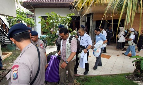 Penyidik KPK dikawal personel Brimob membawa koper usai melakukan penggeledahan di rumah kediaman Ketua DPRD Sumut Ajib Shah, di Jalan Sei Bengawan Medan, Sumatera Utara, Rabu (11/11).