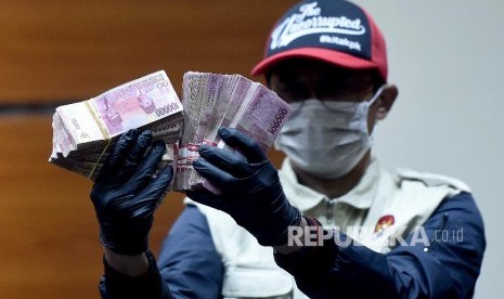 Penyidik KPK menunjukkan barang bukti uang senilai Rp170 juta hasil Operasi Tangkap Tangan (OTT) kasus dugaan suap pengisian jabatan perangkat daerah Pemerintah Kabupaten Kudus tahun 2019 saat konferensi pers di gedung KPK, Jakarta, Sabtu (27/7/2019). KPK menetapkan tiga orang sebagai tersangka, yaitu Bupati Kudus 2018-2023 Muhammad Tamzil, Plt Sekretaris Dinas Pendapatan Pengelolaan Keuangan dan Aset Daerah (DPPKAD) Kabupaten Kudus Akhmad Sofyan dan Staf Khusus Bupati Kudus Agus Soeranto dalam kasus tersebut. 