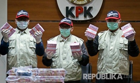 Penyidik menunjukkan barang bukti uang saat konferensi pers terkait Operasi Tangkap Tangan kasus korupsi pejabat pada Kementerian Pemuda dan Olahraga (Kemenpora) serta pengurus Komite Olahraga Nasional Indonesia (KONI) di Gedung KPK, Jakarta, Rabu (19/12/2018) malam. 