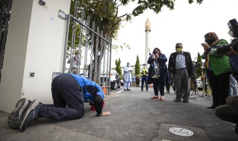 Penyintas peristiwa penembakan Masjid Al Noor, Temel Atacocugu, bersujud usai menyelesaikan perjalanan selama dua minggu dari Dunedin ke Christchurch, Selasa (15/3/2022).