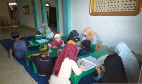 Penyuluh Agama Islam non PNS Kemenag Minahasa Rusna Woy mengajar anak-anak membaca AqQuran di Pineleng, Minahasa, Sabtu (2/3/2024). 