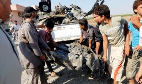 People carry a remnant of a war plane that crashed on the outskirts of Raqqa in northeast Syria September 16, 2014.