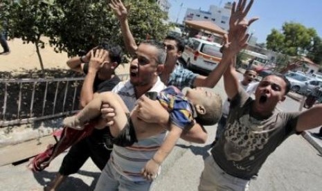 People carry the body of a Palestinian boy whom hospital officials said was killed in an Israeli air strike on his family's house, in Gaza city July 9, 2014. 