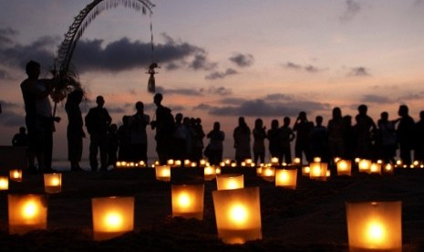 People gather around lit-up candles at Kuta Beach in remembrance of the victims of the Bali Bombing during the 10th anniversary of the incident, in Kuta, Bali October 12, 2012. 