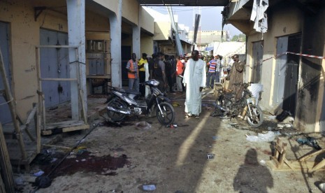 People gather at the scene of a double suicide bomb attack at the Kantin Kwari textile market in Kano December 10, 2014. Four people were killed and seven injured when two female suicide bombers attacked the Kantin Kwari textile market in Nigeria's second 