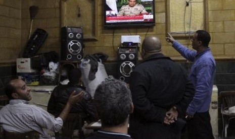 People listen to the speech by Egypt's army chief Field Marshal Abdel Fattah al-Sisi declaring his candidacy for a presidential election, in a public cafe in Cairo March 26, 2014. 