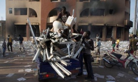 People load goods looted from a building, which according to locals, belongs to Francois Compaore, the younger brother of Burkina Faso's President Blaise Compaore, in Ouagadougou, capital of Burkina Faso, October 30, 2014.