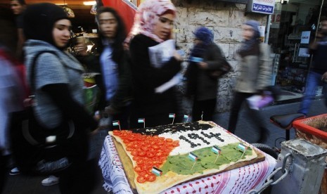 People look at a pizza displayed outside a restaurant, with toppings arranged to depict a Palestinian flag, in the West Bank city of Ramallah November 29, 2012. Italy will support a United Nations resolution on Thursday giving Palestine the status of a 