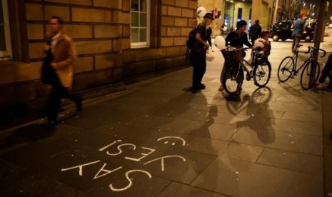 People pass some 'Yes' graffiti on the Royal Mile in Edinburgh, Scotland September 16, 2014.