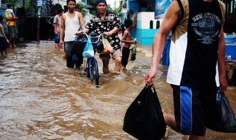 People walk through the flooded area in Jakarta. (illustration)  