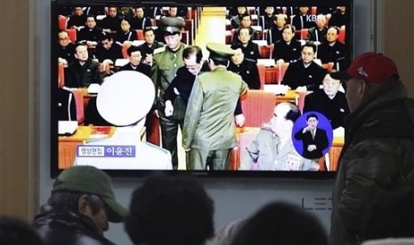 People watch a TV news program at Seoul Railway Station, South Korea, Monday, Dec. 9, 2013 showing Jang Song Thaek, center, uncle of North Korean leader Kim Jong Un, being grabbed during an emergency meeting of Workers Party's Central Committee in Pyongyan