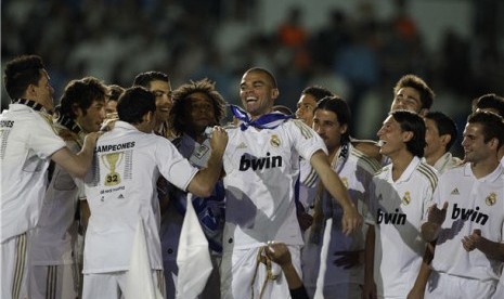 Pepe (tengah), pemain Real Madrid asal Portugal, berfoto bersama rekan setimnya saat merayakan kemenangan merebut gelar juara La Liga Spanyol usai menghadapi Real Mallorca di Stadion Santiago Bernabeu, Madrid, Ahad (13/5). 