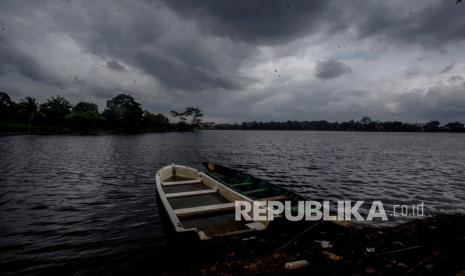 Perahu bersandar dengan latar belakang awan hitam di kawasan Setu Cikaret, Kabupaten Bogor, Jawa Barat, Kamis (10/12/2020). Badan Meteorologi Klimatologi dan Geofisika (BMKG) memperingatkan agar warga waspada bencana hidrometeorologi sepanjang Desember 2020-Februari 2021, hal ini terkait dengan dampak curah hujan tinggi akibat perpaduan musim hujan dan La Nina yang terjadi pada bulan tersebut. 