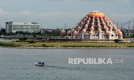 Perahu melintasi perairan Pantai Losari dengan latar belakang Masjid 99 Kubah di Makassar, Sulawesi Selatan, Senin (20/9/2021). Satgas COVID-19 Sulawesi Selatan merilis Kota Makassar keluar dari zona oranye menjadi zona kuning atau kategori wilayah resiko rendah penyebaran COVID-19. 