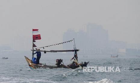 Perahu nelayan berlayar di perairan Teluk Jakarta.