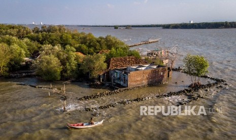 Perahu nelayan melintas di sekitar rumah yang rusak dan ditinggalkan penghuninya akibat abrasi di pesisir Sayung, Demak, Jawa Tengah, Kamis (7/11/2019). 