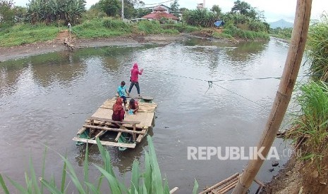 Perahu penyebrangan membawa warga menyebrangi Sungai Citarum, di Desa Andir, Kecamatan Baleendah, Kabupaten Bandung, Selasa (31/1).