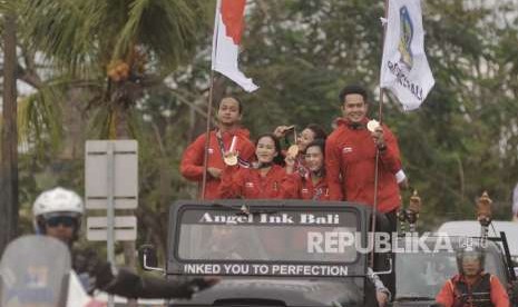 Peraih medali emas cabang olahraga pencak silat Asian Games 2018, Komang Harik Adi Putra (kanan), Ni Made Dwiyanti (kedua kanan), Sang Ayu Sidan Wilantari (kedua kiri), peraih medali perak cabang olahraga Skateboard Sanggoe Dharma Tanjung (kiri) dan peraih medali perunggu cabang Karate Cokorda Istri Agung Sanistyarani (tengah) menujukkan medali saat pawai atlet di Kota Denpasar, Bali, Selasa (4/9). 