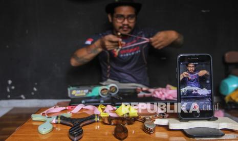 Perajin ketapel membuat video promosi untuk sosial media di Little Margo Catapult, Depok, Jawa Barat, Senin (13/9/2021). Gubernur Jawa Barat Ridwan Kamil mengatakan pertumbuhan ekonomi kreatif pelaku usaha berbasis digitalisasi di Jawa Barat mengalami pertumbuhan 40 persen di tengah pandemi COVID-19. 