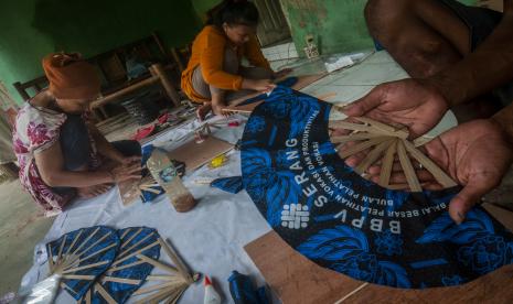 Perajin memproduksi kipas lipat batik lomar Suku Badui di Rangkasbitung, Lebak, Banten, Selasa (18/10/2022). Produksi kipas lipat untuk cenderamata tersebut dijual Rp3 ribu per buah dan dipasarkan melalui daring ke sejumlah kota seperti Jakarta, Tangerang, Depok, dan Bogor. 