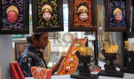  Perajin menata sejumlah hasil kerajinan yang dijual dalam pameran kerajinan Inacraft 2013 di Jakarta Convention Center (JCC), Jakarta, Rabu (24/4).  (Republika/Aditya Pradana Putra)