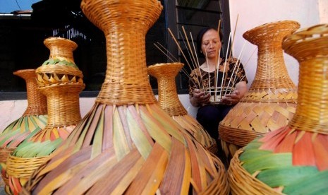 Perajin menganyam bambu untuk dijadikan kerajinan guci. Bambu bernilai ekonomi tinggi bila diolah dengan tepat.