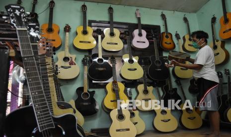 Perajin mengecek kualitas gitar yang telah dibuat di sentra produksi dan perbaikan gitar rumahan di kawasan Pasar Minggu, Jakarta, Jumat (21/8). Ketua Satuan Tugas Pemulihan dan Transformasi Ekonomi Nasional Budi Gunadi Sadikin menyampaikan, pemerintah telah menyalurkan dana banpres produktif usaha mikro sebesar Rp 2,4 triliun dalam satu pekan ini.