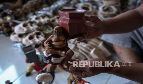 Perajin menunjukkan pot bonsai karyanya di Prambanan, Sleman, DI Yogyakarta.