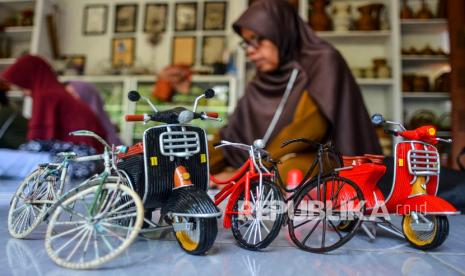 Perajin menyelesaikan miniatur motor dan sepeda di Galuh Peduli Rasa, Desa Dewasari, Kabupaten Ciamis, Jawa Barat, Senin (3/1/2022). Galuh Peduli Rasa memberdayakan ibu rumah tangga untuk memproduksi keranjang, toples, tas, dan miniatur, berbahan limbah kertas yang dipasarkan ke berbagai daerah di Jawa Barat, Bali, dan diekspor ke Nepal dengan harga Rp50 ribu hingga Rp300 ribu. 