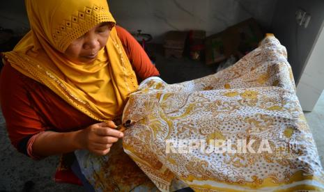 Perajin menyelesaikan pembuatan batik lasem di Desa Karangturi, Lasem, Rembang, Jawa Tengah, Kamis (25/11/2021). Batik dengan ciri khas pesisir hasil akulturasi dari budaya Tiongkok dan Jawa tersebut memiliki motif latohan, naga, sampe