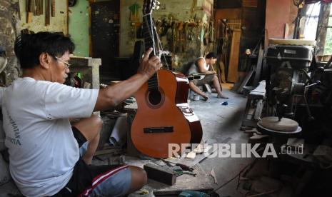 Perajin menyelesaikan pembuatan gitar di sentra produksi dan perbaikan gitar rumahan di kawasan Pasar Minggu, Jakarta, Jumat (21/8/2020). Presiden Joko Widodo menyatakan akan membagikan Bantuan Presiden (Banpres) produktif atau bantuan modal kerja darurat mulai pekan depan sebesar Rp2,4 juta per pengusaha dengan tahap awal diberikan kepada 9,1 juta pelaku Usaha Mikro Kecil dan Menengah (UMKM). 