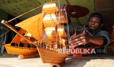 Perajin menyelesaikan pembuatan miniatur perahu layar di Bagansiapiapai, Rokan Hilir, Riau, Sabtu (28/8/2021). Perajin di daerah tersebut memanfaatkan bambu untuk membuat miniatur kapal Lancang Kuning, kapal tongkang China dan perahu Bugis yang dijual seharga Rp150 ribu hingga Rp250 ribu.