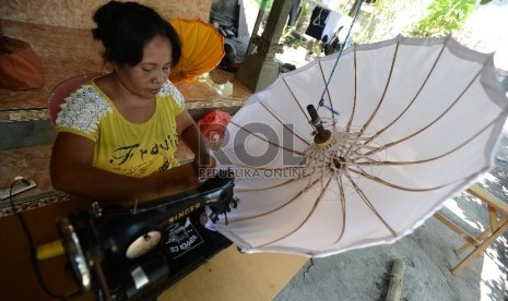   Perajin menyelesaikan proses pembuatan payung adat di Sentra Ukiran UMKM yang dibina oleh PT. ASABRI di Klungkung, Bali,  (Republika/Raisan Al Farisi)