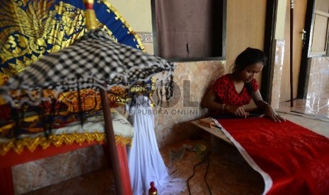 Seorang perajin tengah menyelesaikan pembuatan payung adat di Sentra Ukiran UMKM di Klungkung, Bali,  (Republika/Raisan Al Farisi)