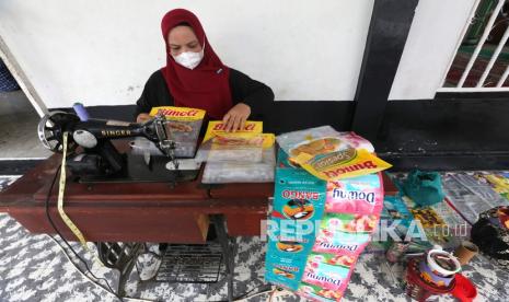 Perajin Usaha Mikro, Kecil dan Menengah (UMKM) menjahit sampah kemasan plastik yang didaur ulang untuk produk kerajinan di Desa Ateuk Jawo, Banda Aceh, Aceh, Kamis (24/2/2022). Kementerian Koperasi dan UKM menargetkan sebanyak satu juta produk UMKM dapat masuk dalam laman Lembaga Kebijakan Pengadaan Barang/Jasa Pemerintah (LKPP) pada tahun 2022 sebagai upaya meningkatkan kesejahteraan perajin dan pemulihan ekonomi nasional. 