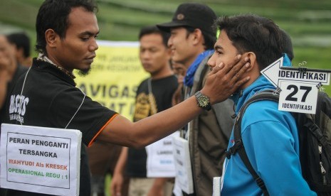 Peran pengganti tersangka memperagakan adegan kekerasan terhadap peserta pada rekonstruksi Diksar Mapala UNISI Universitas Islam Indonesia (UII) di desa Tlogodringo, Tawangmangu, Karanganyar, Jawa Tengah, Senin (13/3). 