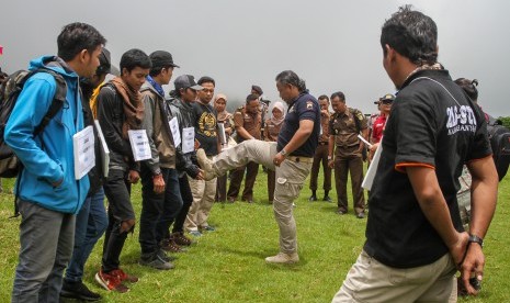 Peran pengganti tersangka memperagakan adegan kekerasan terhadap peserta pada rekonstruksi Diksar Mapala UNISI Universitas Islam Indonesia (UII) di desa Tlogodringo, Tawangmangu, Karanganyar, Jawa Tengah, Senin (13/3). 