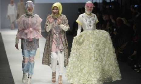 Perancang busana Dian Pelangi (tengah) bersama dua model yang mengenakan busana karyanya tampil dalam pembukaan Jakarta Fashion Week (JFW) 2016 di Jakarta, Sabtu (24/10). 