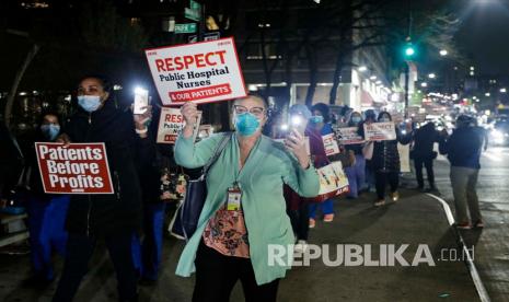 Perawat berbaris untuk menghormati petugas kesehatan dalam memerangi wabah koronavirus di seluruh negeri dan menyerukan disediakannya lebih banyak peralatan pelindung pribadi, di luar Rumah Sakit Lincoln di wilayah Bronx New York, Selasa (14/4). 