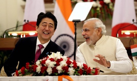 Perdana Menteri India, Narendra Modi (kanan), bersama Perdana Menteri Jepang, Shinzo Abe, bercengkerama usai menandatangani kesepakatan di Gedung Hyderabad, New Delhi, India, Sabtu (12/12). 