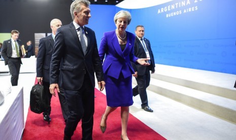 Perdana Menteri Inggris Theresa May berbincang dengan Presiden Argentina Mauricio Macri di sela kegiatan KTT G20 di Buenos Aires, Jumat (30/11).