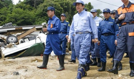 Perdana Menteri Jepang Shinzo Abe (ketiga dari kiri) memeriksa wilayah yang hancur karena banjir di Asakura, prefektur Fukuoka, Jepang, 12 Juli 2017.