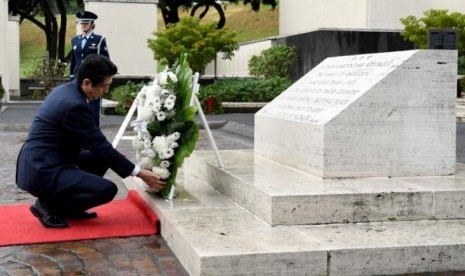  Perdana Menteri Jepang Shinzo Abe meletakkan karangan bunga di pemakaman pahlawan National Memorial Cemetery of the Pacific di Honolulu, Hawaii, Senin (26/12). Pemakaman tersebut bagi korban pengeboman di Pearl Harbour.