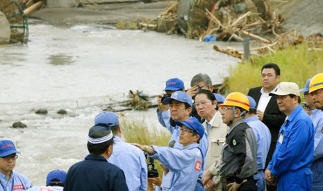 Perdana Menteri Jepang Shinzo Abe (tengah) mengunjungi wilayah barat daya di negara itu yang hancur akibat longsor dan banjir di Hita, prefektur Oita sejak satu pekan terakhir, Rabu (12/7).