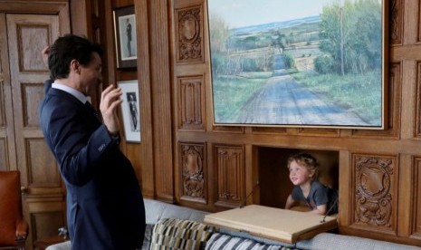 Perdana Menteri Kanada Justin Trudeau sedang bermain petak umpet bersama anak bungsunya, Hadrien, di ruang kerjanya.