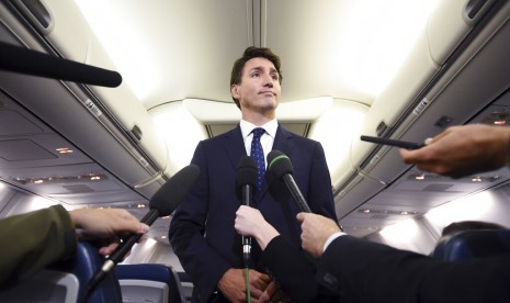 Perdana Menteri Kanada sekaligus pemimpin Partai Liberal Justin Trudeau memberi pernyataan terkait fotonya yang mengenakan make up berwarna cokelat di wajah dan tangannya di masa lalu pada 2001, di pesawat kampanyenya di Halifax, Nova Scotia, Rabu (18/9).