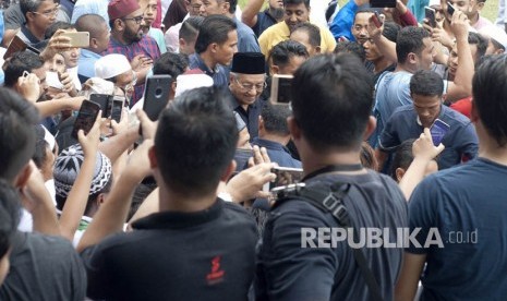 Perdana Menteri ke-7 Malaysia Tun Mahathir Mohamad (tengah) didamping jemaah berjalan seusai Salat Jumat di Masjid Negara, Kuala Lumpur, Malaysia, Jumat (11/5). 