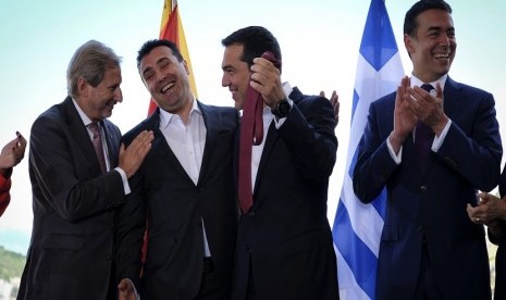 Perdana Menteri Macedonia Zoran Zaev (kedua kiri) secara simbolis menyerahkan dasi kepada Perdana Menteri Yunani Alexis Tsipras (kedua kanan) dihadapan komisioner Uni Eropa dalam penandatanganan antar dua negara di Psarades, Florina, Yunani, Senin (17/6)